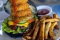 Yummy black burger with onion rings and fries Royalty Free Stock Photo