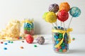 Yummy bright cake pops in glass jar full of candies on table Royalty Free Stock Photo