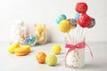 Yummy bright cake pops in glass jar full of marshmallows on table Royalty Free Stock Photo