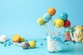 Yummy bright cake pops in glass jar full of marshmallows on table Royalty Free Stock Photo