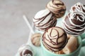 Yummy cake pops coated with chocolate in cup on table, closeup Royalty Free Stock Photo