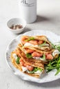 Yummy crepes or thin pancakes with smoked salmon, soft cheese and spinach on a plate close up on gray textured Royalty Free Stock Photo