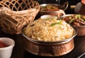 Yummy delicious biryani in a round brass bowl.