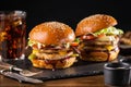 Yummy grilled chicken burger with double cutlet, fries and cola on a wooden table, side view.