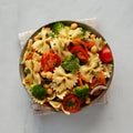 Yummy Homemade Vegan Pasta Salad with Tomato, Onion, Carrot, Broccoli, Chickpeas and Parsley in a Bowl, top view Royalty Free Stock Photo