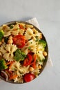 Yummy Homemade Vegan Pasta Salad with Tomato, Onion, Carrot, Broccoli, Chickpeas and Parsley in a Bowl, top view Royalty Free Stock Photo