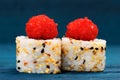 Yummy Japanese fusion rolls with sesame seeds topped with red ro