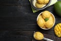 Yummy mango ice cream served on black wooden table, flat lay. Space for text