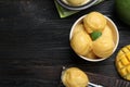 Yummy mango ice cream served on black wooden table, flat lay. Space for text