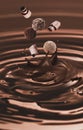 Melted chocolate splashing with falling curls and candies Royalty Free Stock Photo