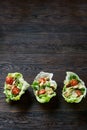 Yummy top view composition of fresh healthy salad served in lettuce leaves on wooden table. Royalty Free Stock Photo