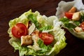 Yummy top view composition of fresh healthy salad served in lettuce leaves on wooden table. Royalty Free Stock Photo