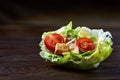 Yummy top view composition of fresh healthy salad served in lettuce leaves on wooden table. Royalty Free Stock Photo