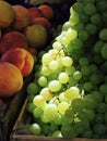 Yumy Grapes and delicious Peaches are wonderfully illuminated in natural light & sunshine Royalty Free Stock Photo