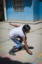 Yungay, Peru, August 8, 2014: Latin girl with indigenous features touching the floor painted with chalk playing hopscotch