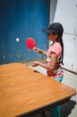 Yungay, Peru, August 8, 2014: portrait of girl in cap playing ping pong with racket in hand giving ball