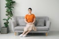 Yuong woman sitting on her white sofa Royalty Free Stock Photo