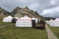 Yurt camp surrounded by trees on the ridge of the mountain. Small ger huts on the crest of the hill on a cloudy day