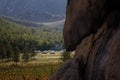 Yurt camp surrounded by trees on the ridge of the mountain. Small ger huts on the crest of the hill on a sunny day