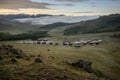 Yurt camp surrounded by trees on the ridge of the mountain. Small ger huts on the crest of the hill on a sunny day