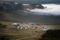 Yurt camp surrounded by trees on the ridge of the mountain. Small ger huts on the crest of the hill on a sunny day