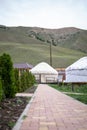 White yurt with red and brown traditional patterns on a green hill