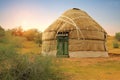 The yurt is in the steppe against the background of nature and the sky illuminated by the sun at sunset.
