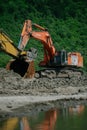 A Hitachi excavator works at a construction site digging a pit.