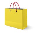 Yellow paper shopping bag with red rope handles isolated on white background