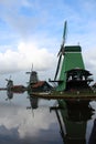 A CLASSIC WINDMILL REFLECTING AT THE CALM WATERS OF ZAANSE SCHANS