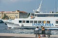 Zadar, Croatia - Aug 13, 2020: Family rest on bench by old town harbour in afternoon