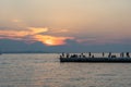 Zadar, Croatia - Aug 12, 2020: Sunset at Adriatic sea with tourists at pier