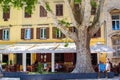 Zadar, Croatia; 07/17/2019: Big tree with a bar terrace and a yellow typical croatian house at the background, in the old town of
