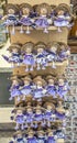 Wooden dolls dressed in purple outfits.