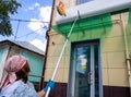 Washing the facade of the building with a long brush Royalty Free Stock Photo