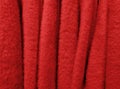 Close-up Full frame photo of warm red sweaters on hangers in store.