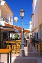 Idyllic quiet atlantic coastal town with white houses, small narrow alley with bars and restaurants, blue summer sky