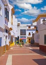 Tranquil street scene in typical spanisch atlantic ocean village, empty siesta pedestrian road, white houses, blue summer sky