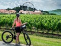 Zajeci, Czech Republic - July 20, 2020: Caucasian female cyclist looking at vineyards.