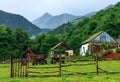 Zakan, Russia. Caucasus Mountains countryside. Rustic house in forest on Lugan mountain peak background. Scenic summer landscape