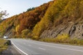 The car moves along a winding asphalt road among the mountains.