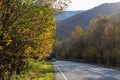 The car moves along a winding asphalt road among the mountains.