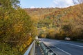 Among the mountains, on the side of a deserted asphalt road, there is a parked car.