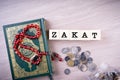 Zakat concept: Quran and tasbih with jar full of coins