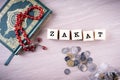 Zakat concept: Quran and tasbih with jar full of coins