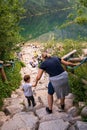 Zakopane, Poland: Back view of a mother holds a hand of a her child walking town stairs to morskie oko lake