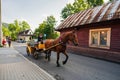 Zakopane, Poland: A man riding a horse carriage or cart on a street against a house during day Royalty Free Stock Photo