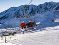 Sport is health. A pair of skiers going by Gasienicowa chairlift - Polish Cable Railways, to the top of Kasprowy Wierch. Tatra