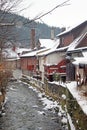 Zakopane town during the snowing, trees, fences and old houses along the mountain stream Royalty Free Stock Photo