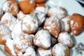 Zalabia covered with powdered sugar on a white plate, a type of middle eastern fried dough similar to that of a doughnut